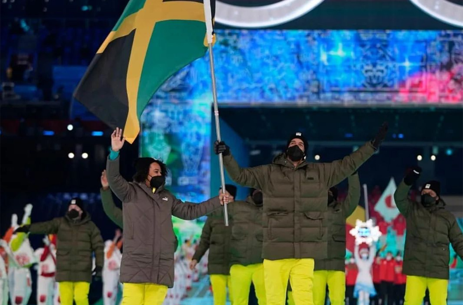 Benji Alexander carrying the flag for Jamaica at the 2022 Olympic Winter Games opening ceremony